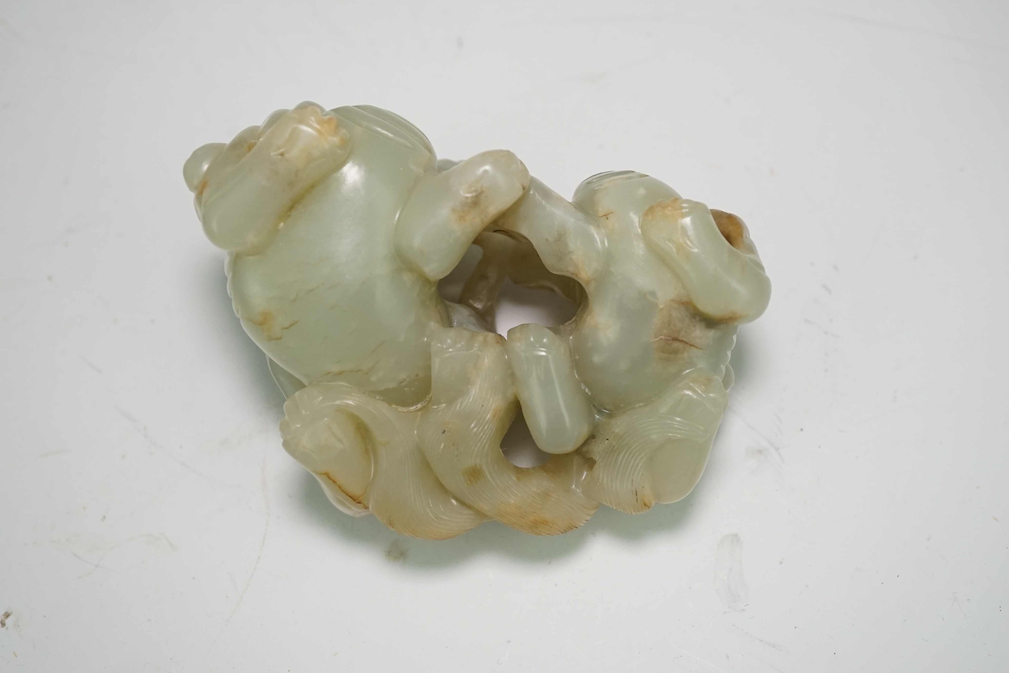 A Chinese celadon and russet jade group of two lion-dogs, 19th century